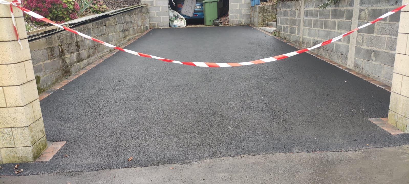 Entrée de garage après travaux — cour bitume refaite — JS Aménagement